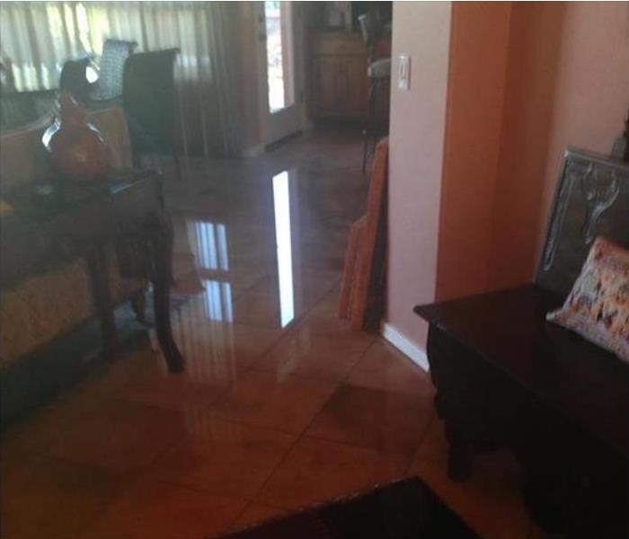 flooded water reflecting off a tiled floor with furnishings