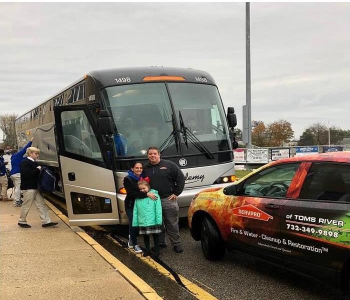 The Reilly Family standing by bus they rented to Donovan Catholic High School Football Team to take them to the game